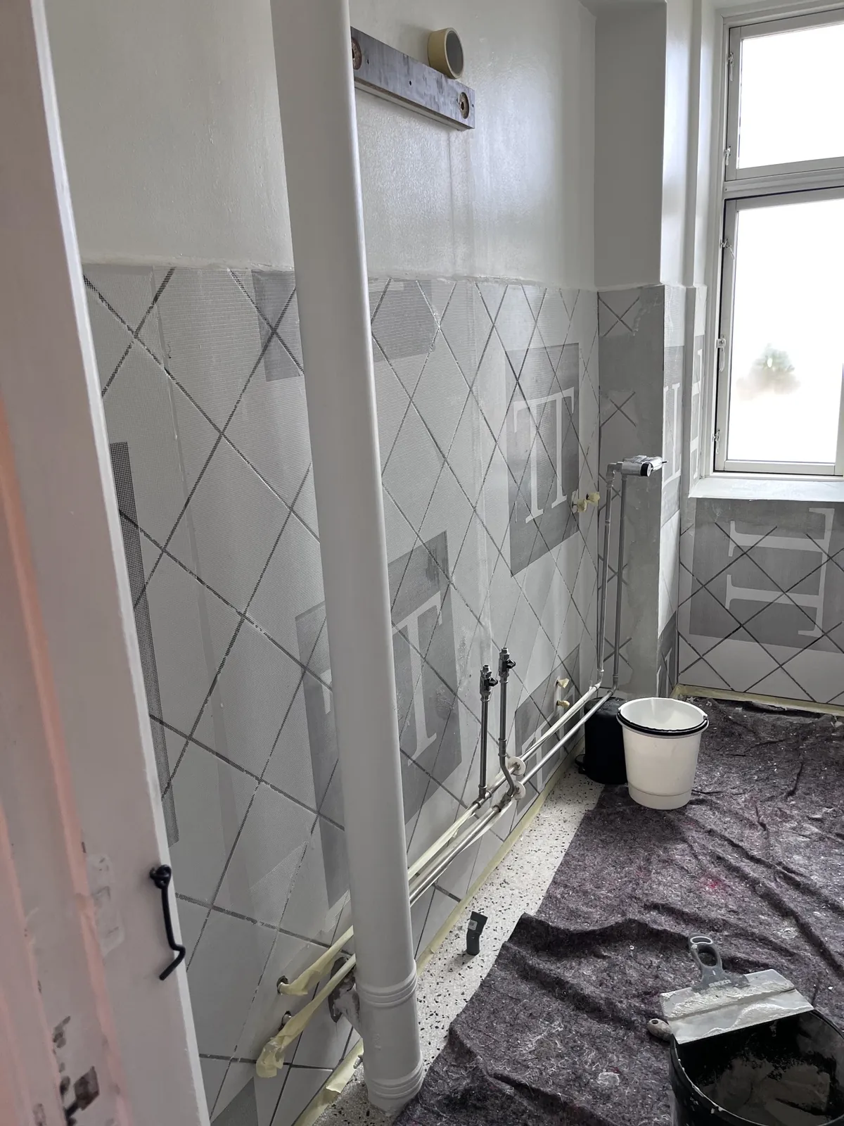Badeværelse med fliser under renovering og afdækket gulv – Maler Microcement, Herlev og omegn