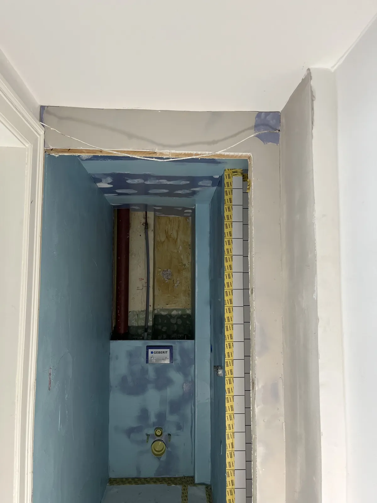 Badeværelse under renovering med blå væg og indbygget cisterne – Maler Microcement, Herlev og omegn