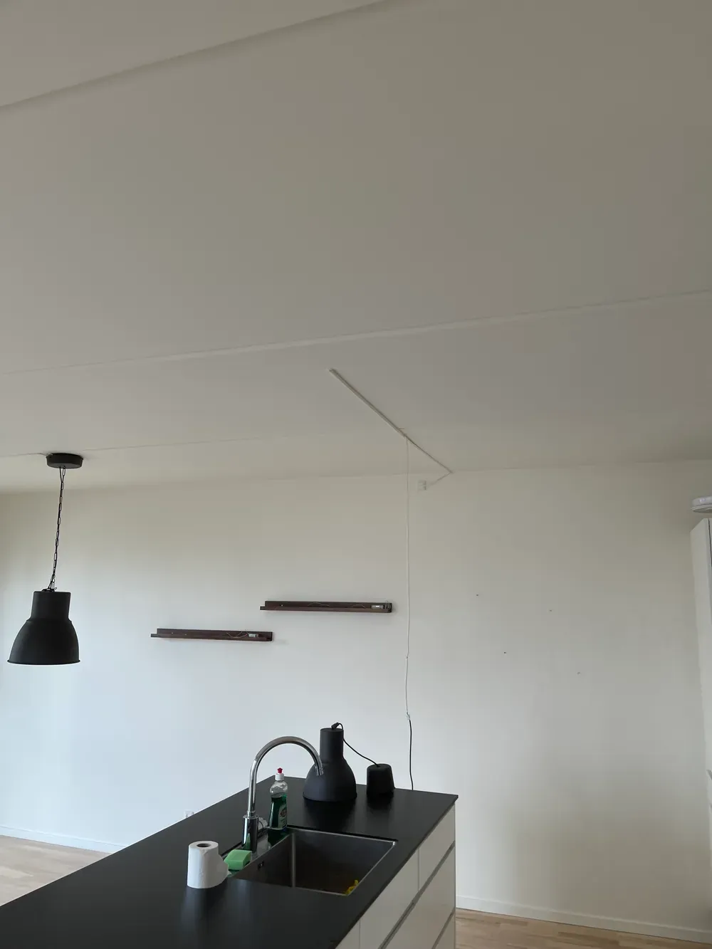 Køkkenø med sort bordplade og pendellampe – Maler Microcement, Herlev og omegn