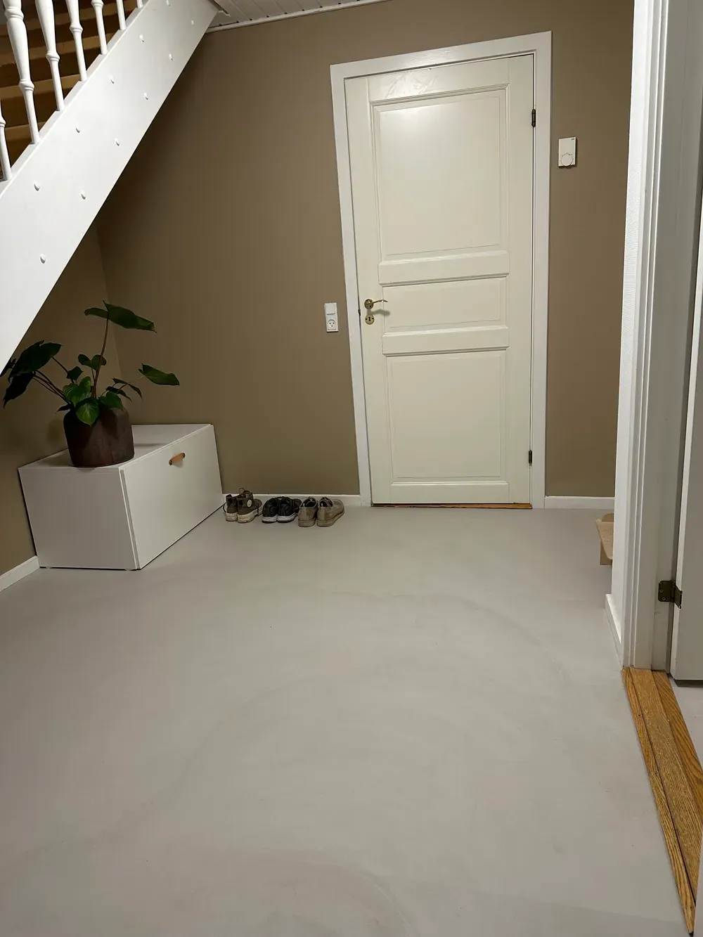 Entre med lysegråt microcementgulv og hvid dør – Maler Microcement, Herlev og omegn